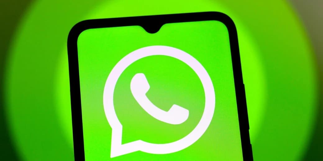 The WhatsApp logo displayed on a smartphone against a bright green background.