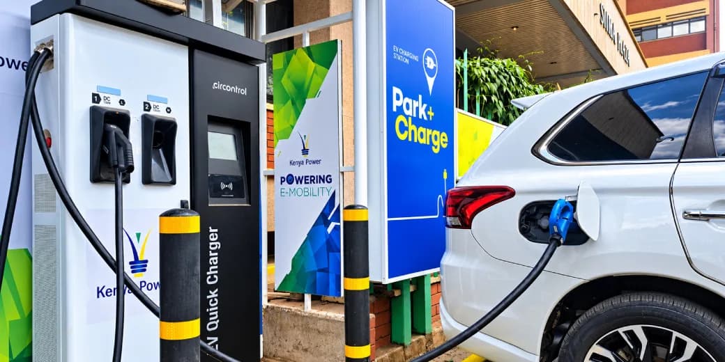 A white electric vehicle connected to a Kenya Power public charging station.
