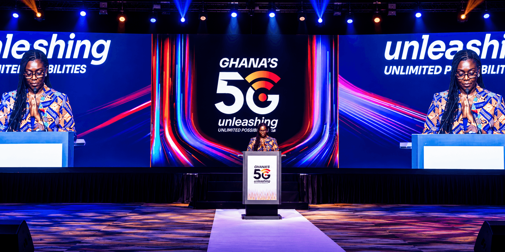 A speaker presenting on a brightly lit stage at a Ghana 5G launch event.