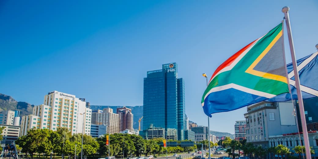 South African flag in front of a Cape Town business district skyline. Credit: HERE Technologies.