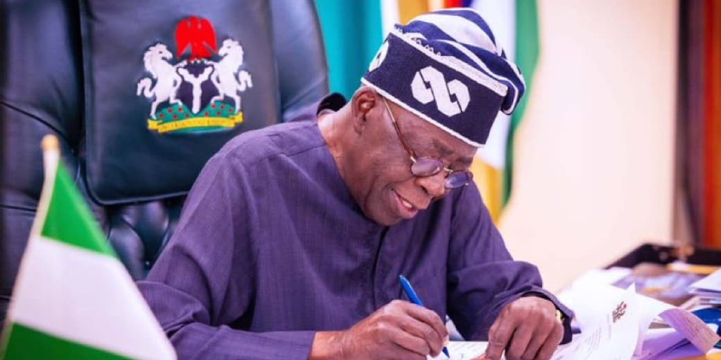 President Bola Tinubu signing a document linked to Nigeria's identity framework. Credit: NIMC.