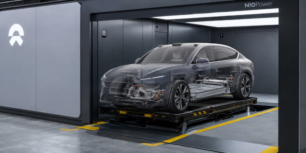 Transparent rendering of a Nio electric vehicle showing its floor-mounted battery inside a swap station.