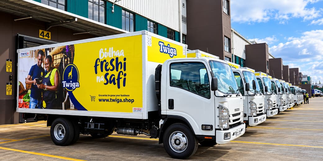 A row of Twiga Foods delivery trucks outside a distribution facility.