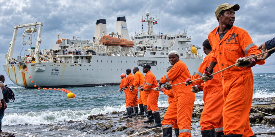 Workers haul part of a fibre optic cable onto the shore of the Kenyan port city of Mombasa on June 12, 2009