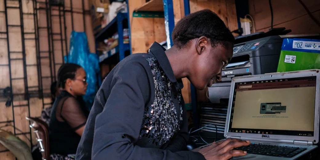 A customer using a laptop inside a Kenyan cyber cafe.